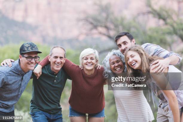 mehrgenerationenbildung von freunden, die draußen zusammen posieren - erwachsene person stock-fotos und bilder