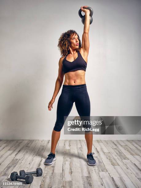 young woman athlete working out with kettleball weight - black female bodybuilder stock pictures, royalty-free photos & images