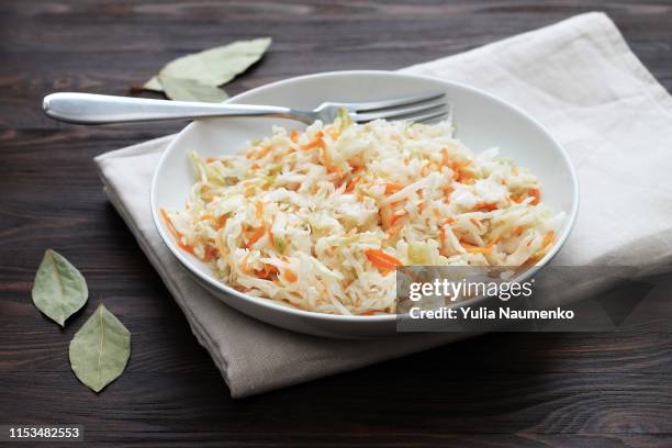 fermented cabbage. vegan food. sauerkraut with carrot and spices in bowl on the dark background. trend food. - sliced pickles stockfoto's en -beelden