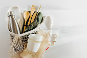 Mesh market bag with bamboo cutlery, reusable coffee mug  and  water bottle. Sustainable lifestyle.  Plastic free concept.