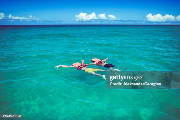 friends playing dead with life vests at the beach - playing dead stock pictures, royalty-free photos & images