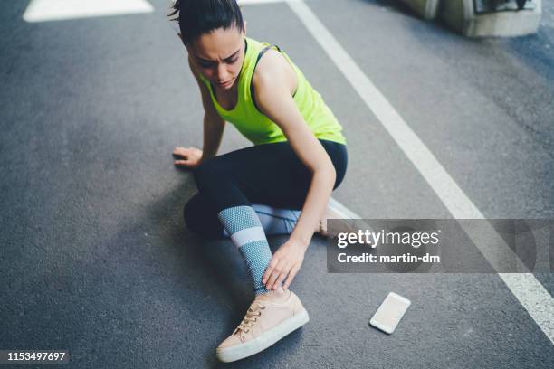 sportswoman with injured ankle - twisted ankle stock pictures, royalty-free photos & images