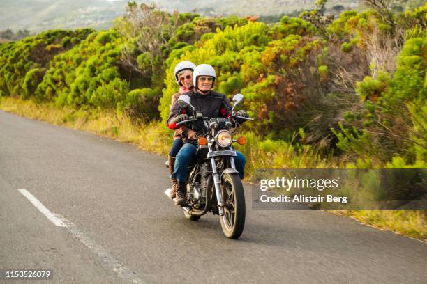 retired couple on a motorbike ride together on a country road. - motorized vehicle riding stock-fotos und bilder