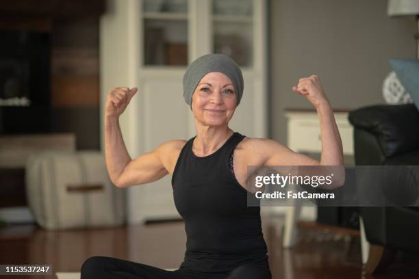 senior woman with cancer flexing - cancer survivor stock pictures, royalty-free photos & images