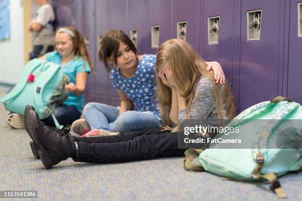 a friend consoling her friend at an elementary school - showing compassion stock pictures, royalty-free photos & images