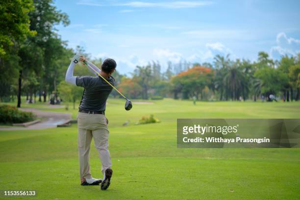 man playing golf on a golf course - golf swing imagens e fotografias de stock