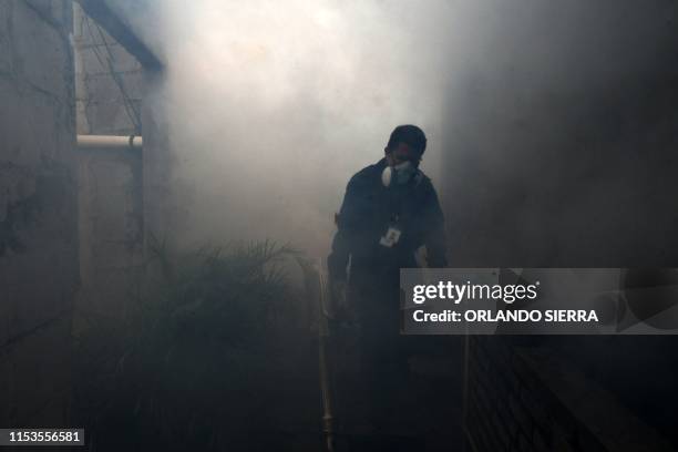 An employee of the Honduran Secretariat of Health takes part in a fumigation operation to combat Aedes aegypti, vector of the dengue fever in...