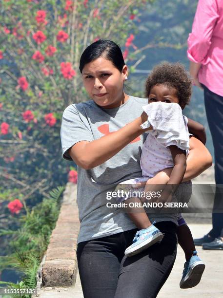 Woman covers a child's face during a fumigation operation to combat Aedes aegypti, vector of the dengue fever at El Bosque neighborhood in...