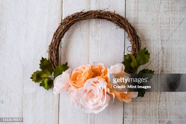 high angle close up of a small wreath with pale and salmon pink paper roses. - paper flower stock-fotos und bilder