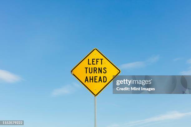 left turns ahead yellow traffic sign - segnaletica stradale foto e immagini stock