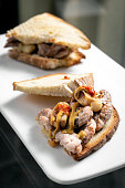 traditional portuguese bifana marinated spicy pork sandwich snack with mustard piri piri sauce and garlic in lisbon cafe