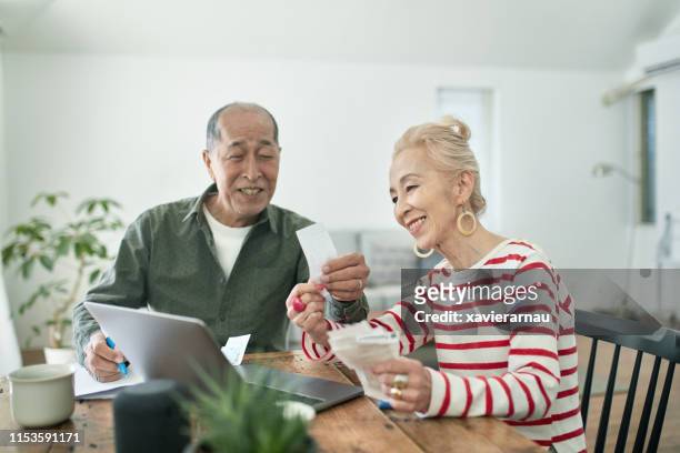 senior japanese couple managing home finances - demonstration against the marriage for all bill stock pictures, royalty-free photos & images