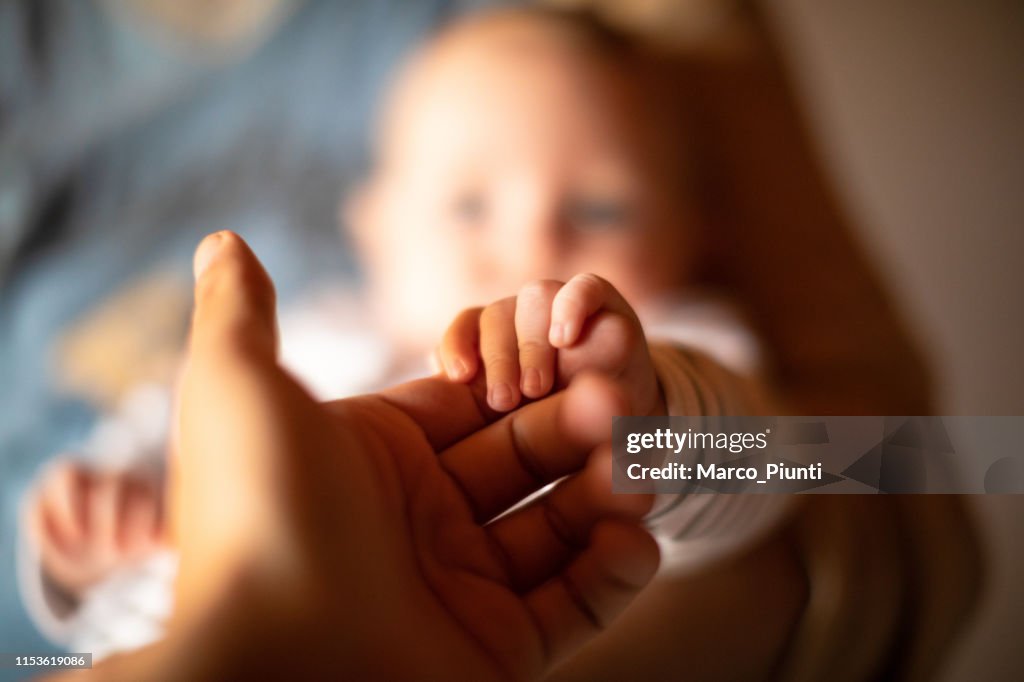 Hand hält Neugeborenebaby Hand
