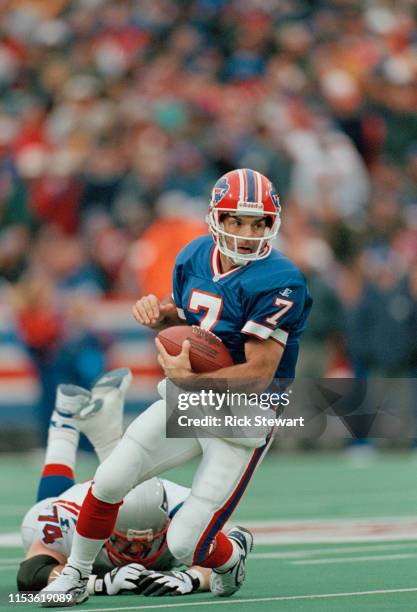 Doug Flutie, Quarterback for the Buffalo Bills evades the tackle of Chris Sullivan during the American Football Conference East game against the New...