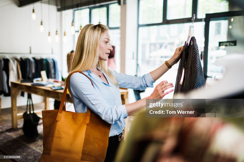 Woman Reading Label On Clothing While Out Shopping