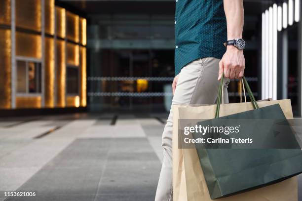 man's legs and shopping bags outside a luxury mall - luxury apparel bildbanksfoton och bilder