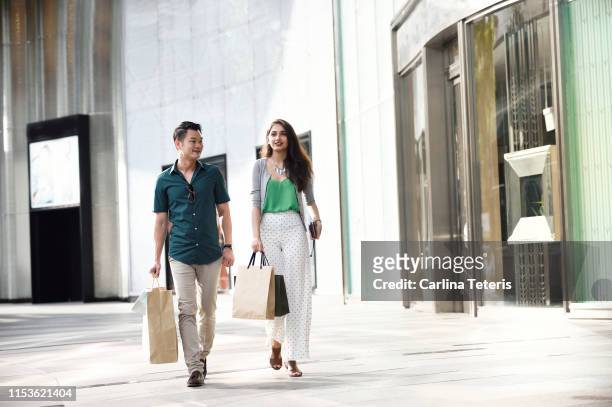 singaporean couple shopping on orchard road - chinese young adults shopping imagens e fotografias de stock