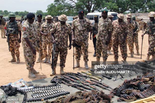 Military commanders inspect arms and ammunitions recovered from Boko Haram jihadists on display at the headquarters of the 120th Battalion in Goniri,...