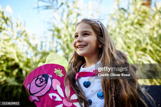 happy little girl with school cone in a field - schulbeginn stock-fotos und bilder