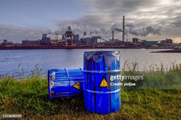 chemical waste drums in front of heavy industry - chemical plant stock pictures, royalty-free photos & images