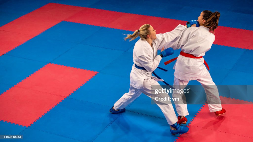 Praticanti di karate femminile che lottano su un tappeto tatami