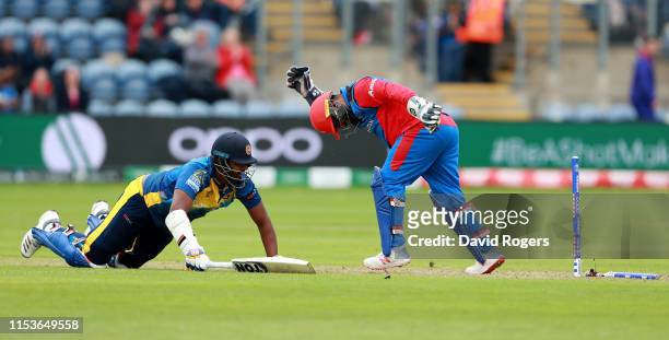Thisara Perera of Sri Lanka is run out as Mohammad Shahzad looks on during the Group Stage match of the ICC Cricket World Cup 2019 between...