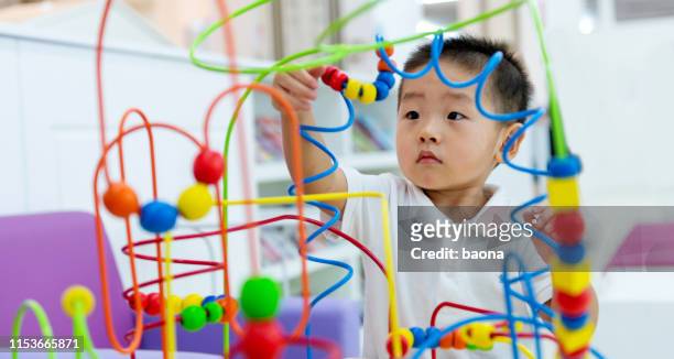 littl boy working on a puzzle - toddler toys stock pictures, royalty-free photos & images