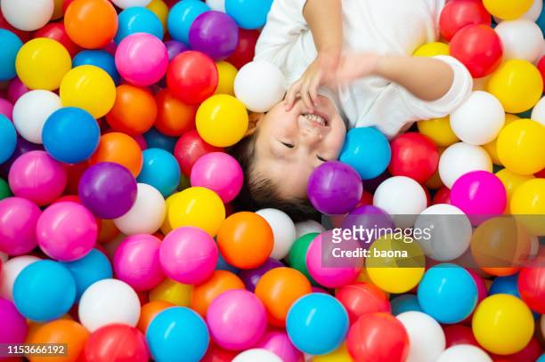 two year old boy on the ball pool - extreem weer stock pictures, royalty-free photos & images