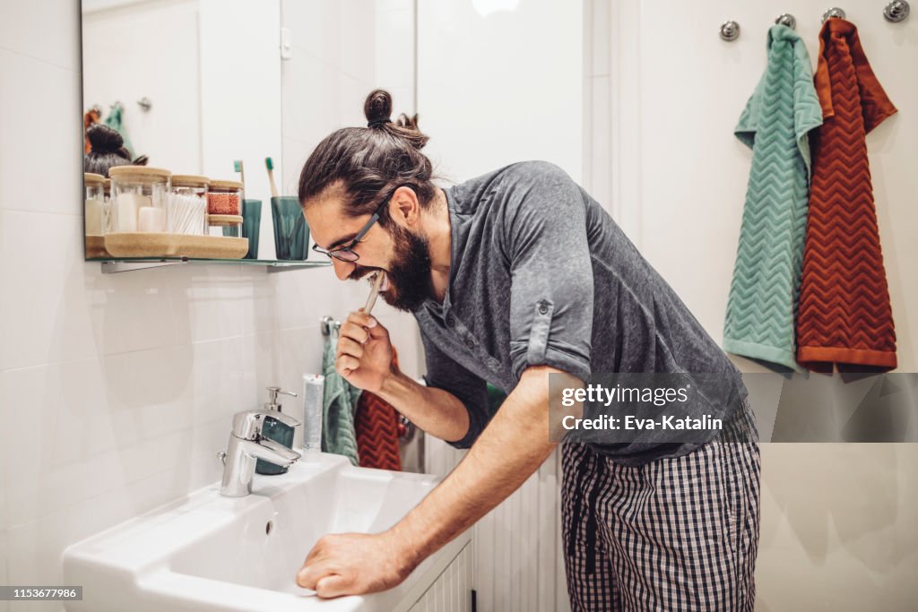 At home - young man brushing his teeth