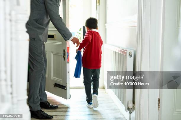 schoolboy leaving house with book bag on way to school - uk now stock pictures, royalty-free photos & images