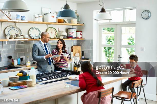 woman eating breakfast and listening to husband with digital tablet - filipino family eating stock pictures, royalty-free photos & images