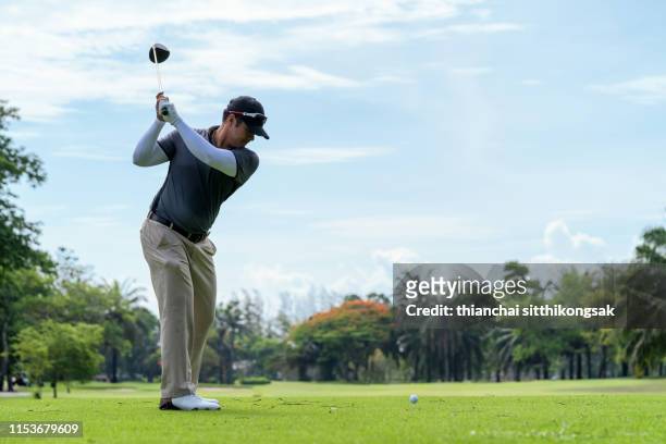 man playing golf in a golf course - golf driver stock pictures, royalty-free photos & images