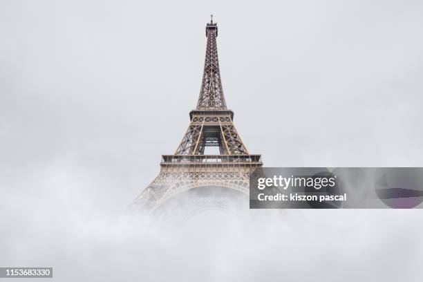 eiffel tower in paris disappearing in the fog . french culture . - torre eiffel imagens e fotografias de stock