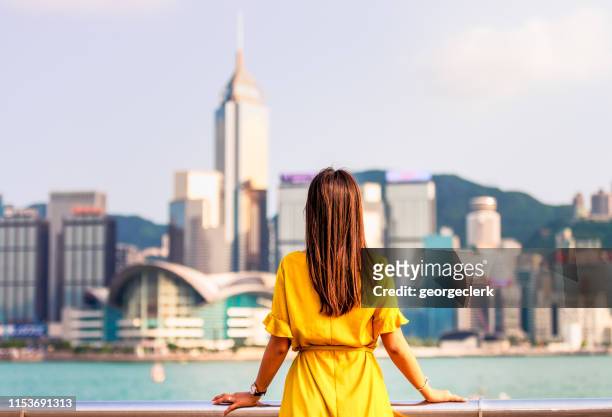 overlooking victoria harbour in hong kong - yellow dress stock pictures, royalty-free photos & images