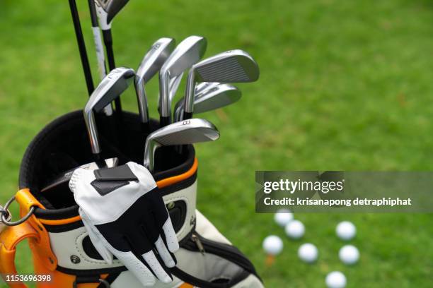 set of golf clubs over green field background,olf clubs drivers over green field background - pga wedstrijd stockfoto's en -beelden