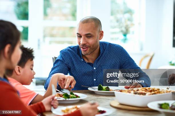 father pointing at fresh vegetables on son's plate - bruder schwester kochen stock-fotos und bilder