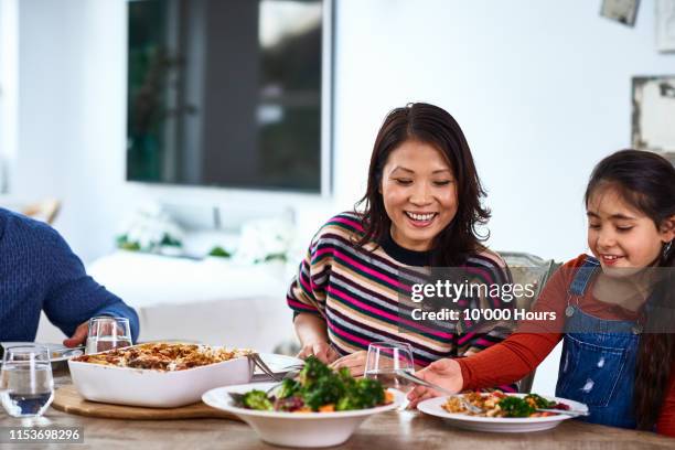 young girl and mother enjoying healthy meal together - asian mother cooking imagens e fotografias de stock