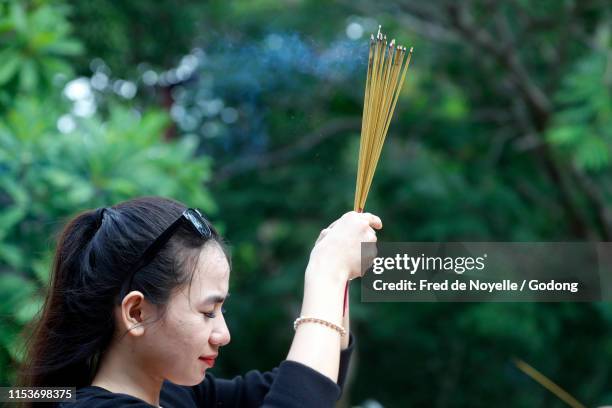 ho phap buddhist temple. woman praying. incense sticks.  vung tau. vietnam. - phap ho stock pictures, royalty-free photos & images