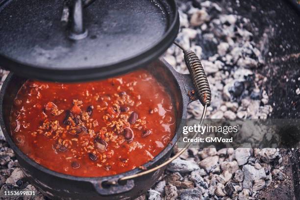 chili con carne in niederländischem ofen über logfire gekocht - chili con carne stock-fotos und bilder