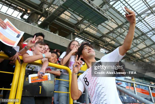 Kyuhyuk Lee of Korea Republic takes a selfie photograph as he celebrates victory with fans after the 2019 FIFA U-20 World Cup Round of 16 match...