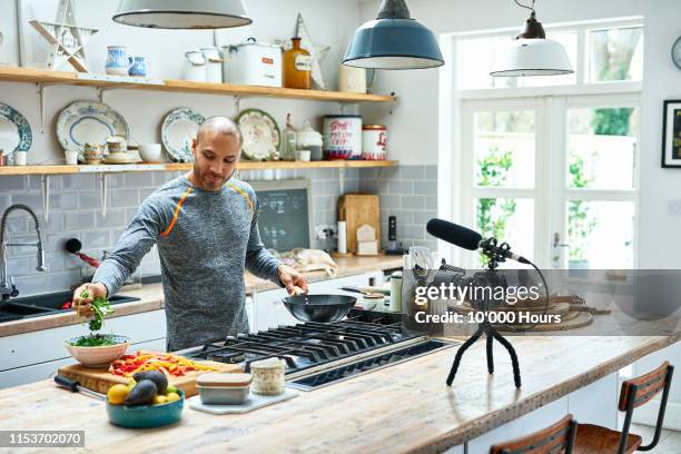mature man making meal and using camcorder - cooking healthy stock pictures, royalty-free photos & images