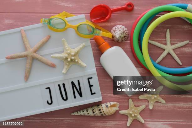 "june" message in light box with summer complements. summer concept. - june sale stock pictures, royalty-free photos & images