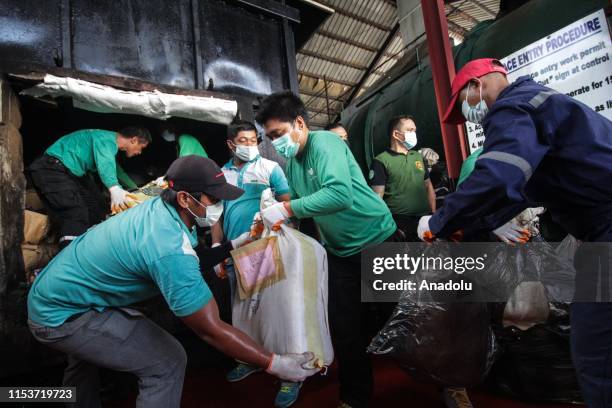 Philippine Drug Enforcement Agency personnel load seized illegal drugs into an incinerator for destruction at a waste facility in Trece Martires,...