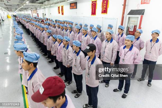Employees line up for row call before their shift starts at a Pegatron Corp. Factory in Shanghai, China, on Friday, April 15, 2016. This is the realm...
