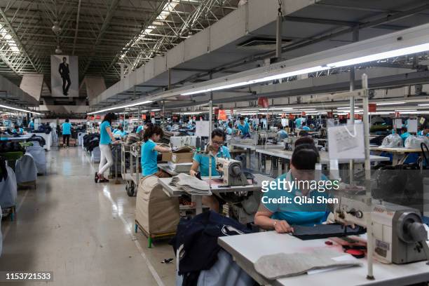 Employees make suits at a factory operated by the Shandong Ruyi Technology Group in Jining, China, on Monday, May 30, 2016. Shandong got a boost in...