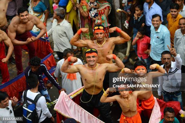 Indian bodybuilders pose as they participate in the 142nd annual Rath Yatra of Lord Jagannath in Ahmedabad on July 4, 2019. - Idols of Lord...