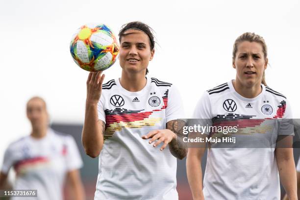 Dzsenifer Marozsan plays with a ball next to Verena Schweers during a training session of the German women's national football team on June 04, 2019...