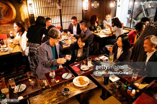 工作的朋友們用日本居酒屋互相敬酒 - 吧 公共飲食地方 個照片及圖片檔