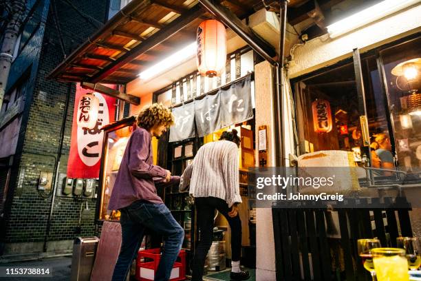 giovane coppia che entra in giapponese izakaya - japanese restaurant foto e immagini stock