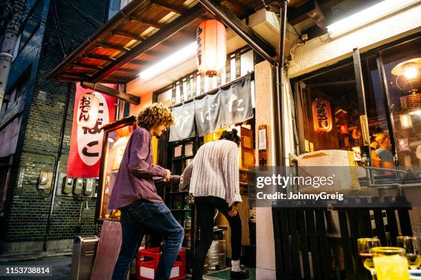 young couple entering japanese izakaya - dodge stock pictures, royalty-free photos & images